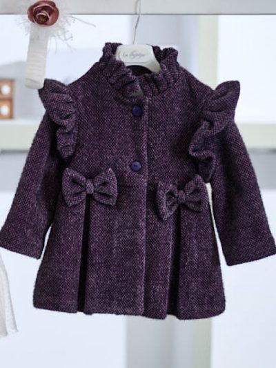 Παλτό, εμπνευσμένο από την βικτωριανή εποχή, από βελουτέ ύφασμα με περίτεχνη πλεκτή υφή. Οι μοναδικές λεπτομέρειες όπως ο μάο γιακάς, το λοξό βολάν στα μανίκια, τα φιογκάκια αλλά και οι κουφόπιετες το καθιστούν ιδανικό για την απόλυτη χειμερινή βάπτιση. Μια επιλογή ταιριαστή με όλα τα φορέματα της συλλογής.