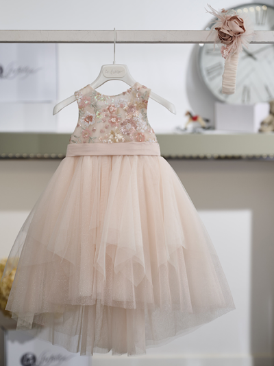 Η ρομαντική αισθητική και η διακριτική λάμψη συνδυάζονται αρμονικά σε αυτό το εντυπωσιακό βαπτιστικό φόρεμα σε σομόν απόχρωση, δημιουργώντας μια κομψή και φίνα εμφάνιση.