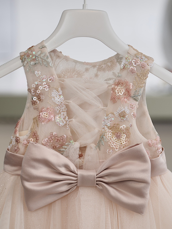 Η ρομαντική αισθητική και η διακριτική λάμψη συνδυάζονται αρμονικά σε αυτό το εντυπωσιακό βαπτιστικό φόρεμα σε σομόν απόχρωση, δημιουργώντας μια κομψή και φίνα εμφάνιση.