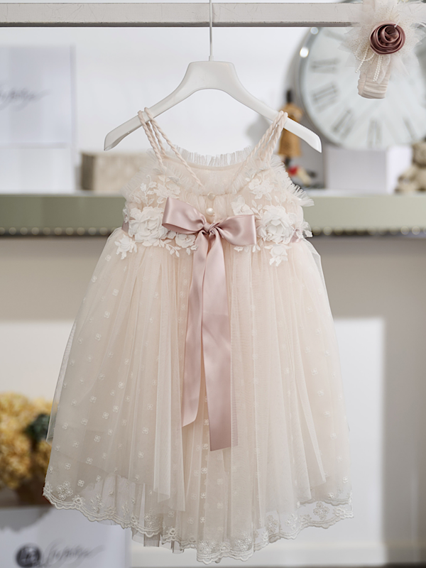 Φίνα υφάσματα και εκλεπτυσμένες λεπτομέρειες συνθέτουν ένα ιδιαίτερα καλαίσθητο βαπτιστικό φόρεμα, ιδανικό για μια κομψή εμφάνιση την ημέρα της βάπτισης. Η απαλή βανίλια απόχρωση αναδεικνύει το τούλι και τη δαντέλα, δημιουργώντας ένα αέρινο και διαχρονικό αποτέλεσμα.