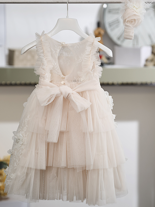 Η ρομαντική πολυτέλεια και η πλούσια διακόσμηση συνθέτουν ένα εντυπωσιακό βαπτιστικό φόρεμα σε απαλή βανίλια απόχρωση, εμπνευσμένο από τη διαχρονική αισθητική του μπαρόκ. Τα φίνα υφάσματα και οι περίτεχνες λεπτομέρειες δημιουργούν μια ιδιαίτερα κομψή και ξεχωριστή εμφάνιση.